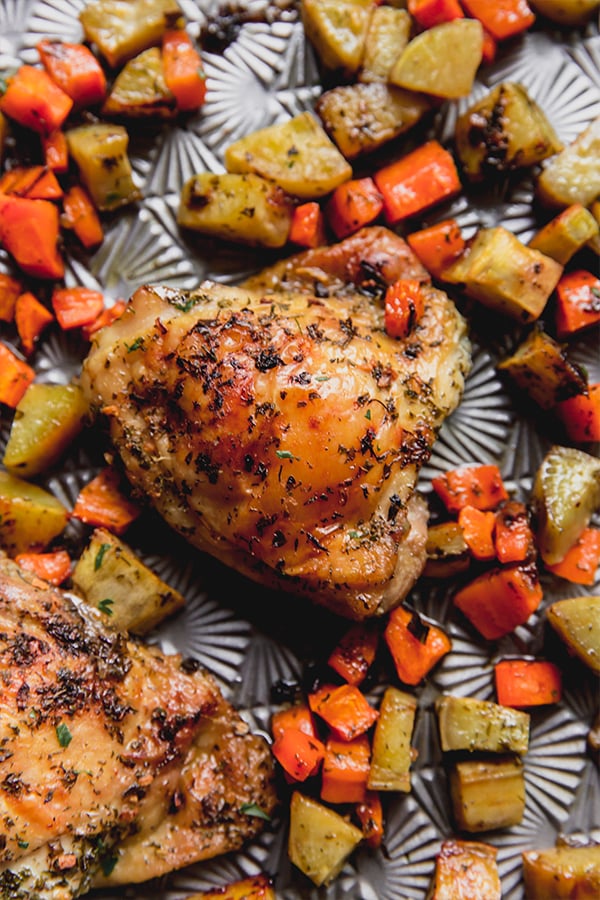 A close up of the ranch chicken sheet pan dinner showing a chicken thigh and vegetables.
