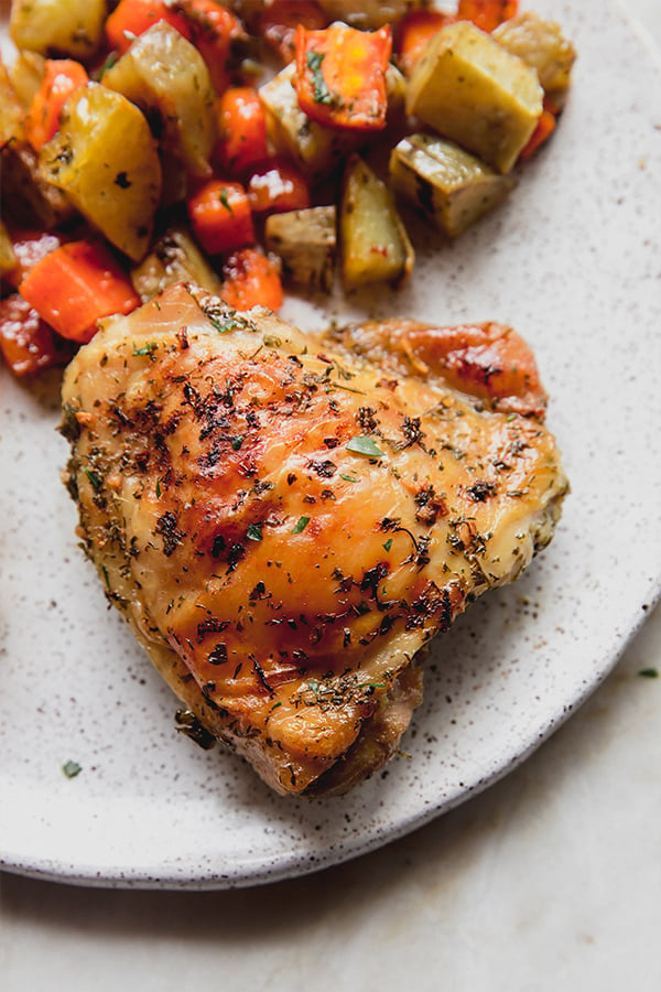 A plate with ranch chicken and vegetables from the sheet pan.