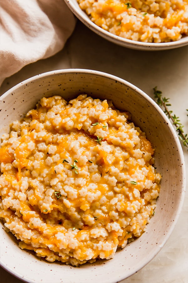 A bowl of butternut squash stelline next to another bowl of butternut squash stelline.