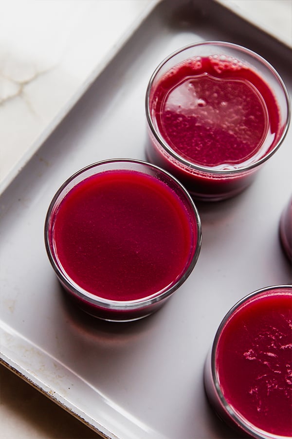 Cups filled with pomegranate jello mixture before setting.