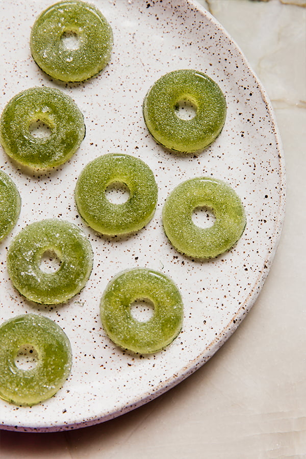A plate filled with sour apple ring gummies.