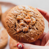 Person with a ghost painted on their nail holding a coffee cake cookie.