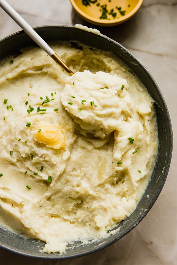 A serving bowl of instant pot mashed white sweet potatoes sitting on the counter.