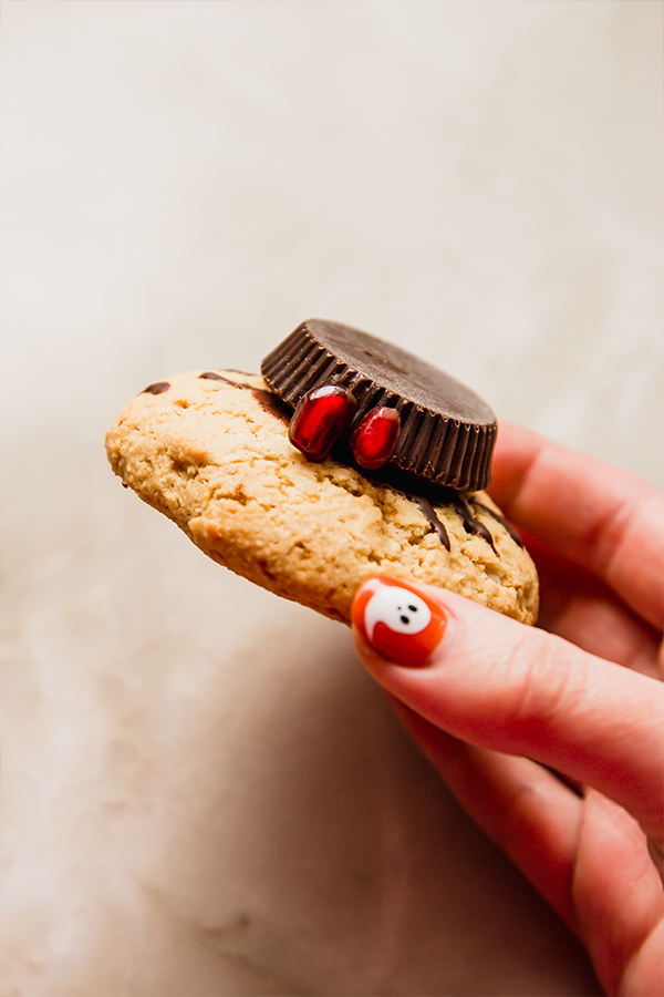 A spider cookie being held in a hand.