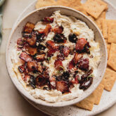 Bowl of bacon date whipped cream cheese dip with crackers.