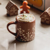 Gingerbread hot cocoa with whipped cream in a mug.
