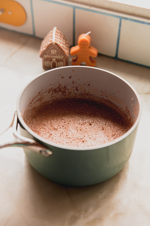 A pot of gingerbread hot cocoa ready to be poured into mugs.