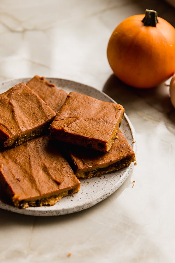 A serving plate with pumpkin pie cookie bars sitting on a counter.