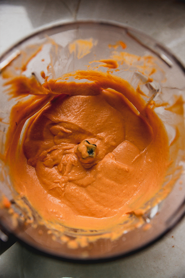 A blender filled with pumpkin cream filling after blending.