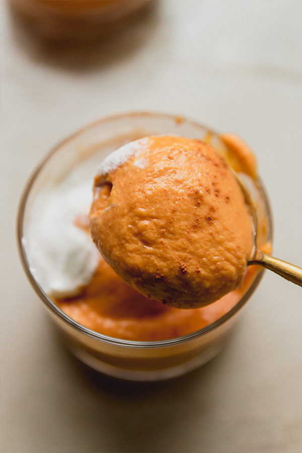 A spoon lifting a spoonful of pumpkin cream out.