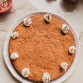 Gingerbread cookie cake with dollops of whipped cream on a plate.