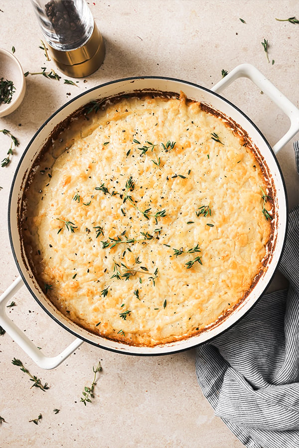 A skillet filled with french onion shepherd's pie after being baked.