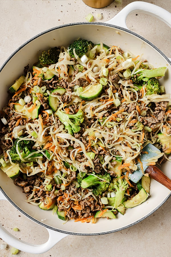 A large skillet filled with ground beef and cabbage stir fry after having been cooked.