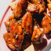 Lemon garlic chicken wings on a pink plate.