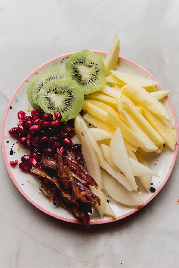 A plate with the cut up fruit for putting in the fruit rice paper rolls.