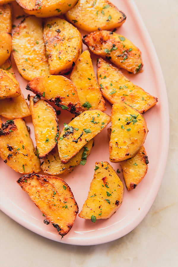 A serving dish of Greek lemon style sweet potatoes ready to be eaten.