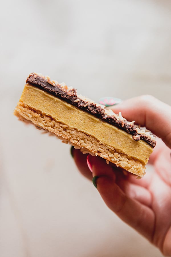 A lemon coconut s'mores bar being held in a hand.