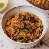 Steak fried rice in a bowl topped with chopped with green onion.