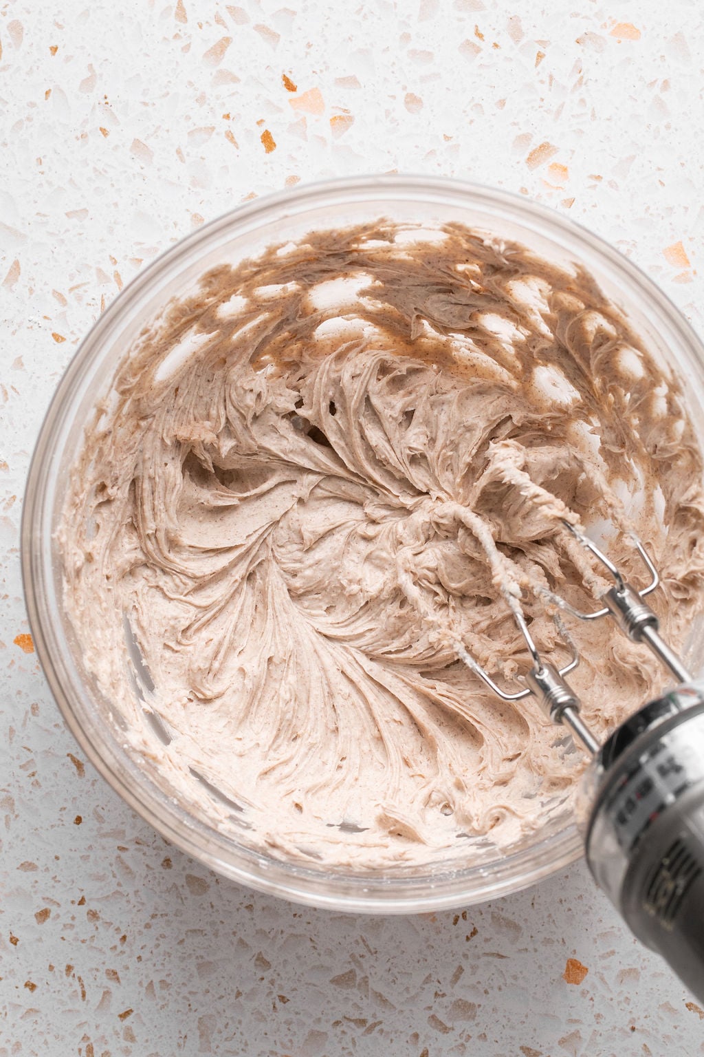 Pumpkin spice icing ingredients, being whisked.