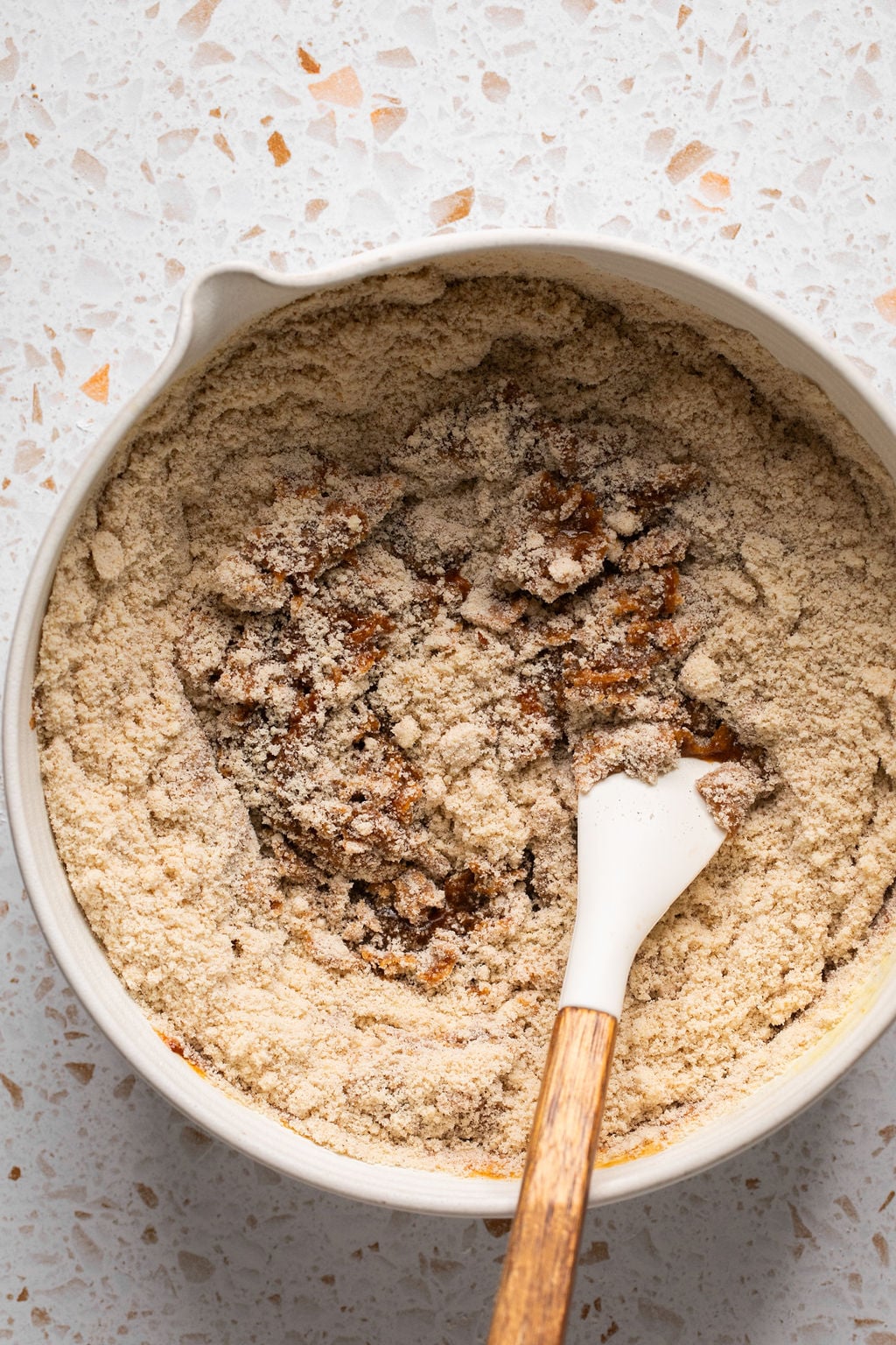 Pumpkin spice cookie wet and dry ingredients being whisked in a bowl.