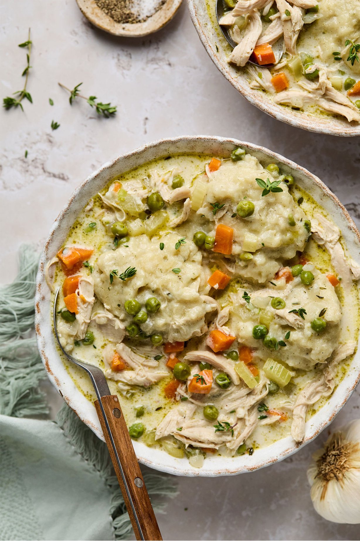 Chicken and dumplings in a bowl with a spoon.