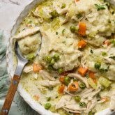 Gluten free chicken and dumplings in a bowl with a spoon.