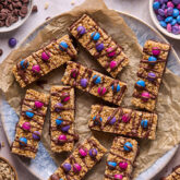 Kudos bars topped with candy gems and chocolate laid out on a platter.