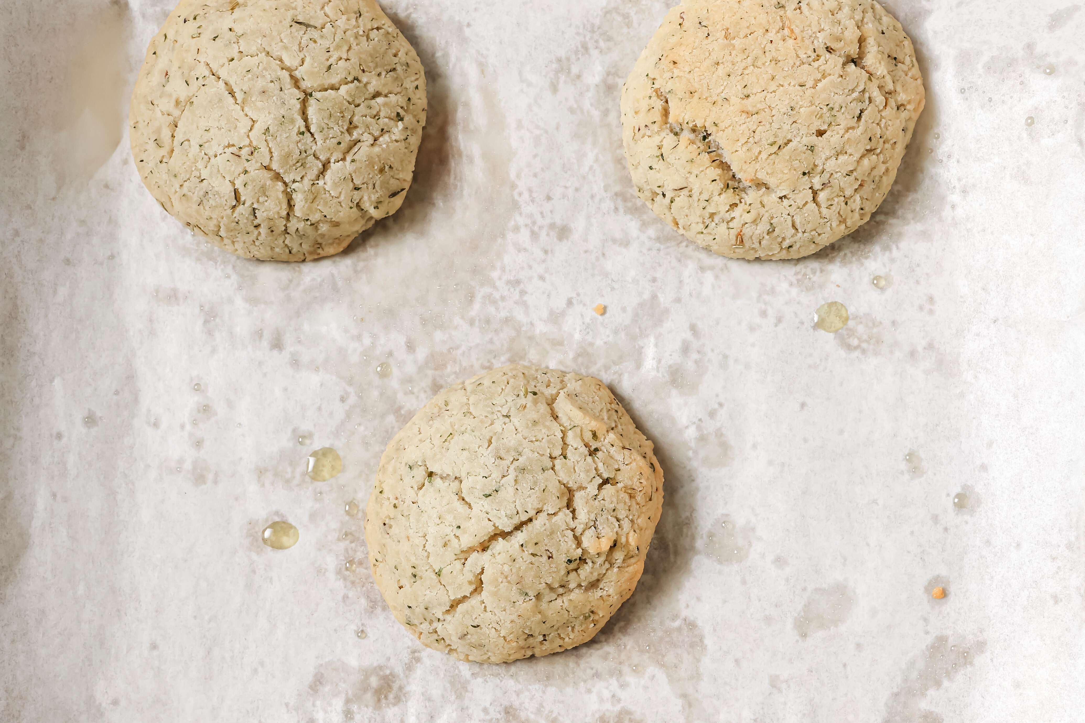 Five cooked bread rolls on a baking sheet