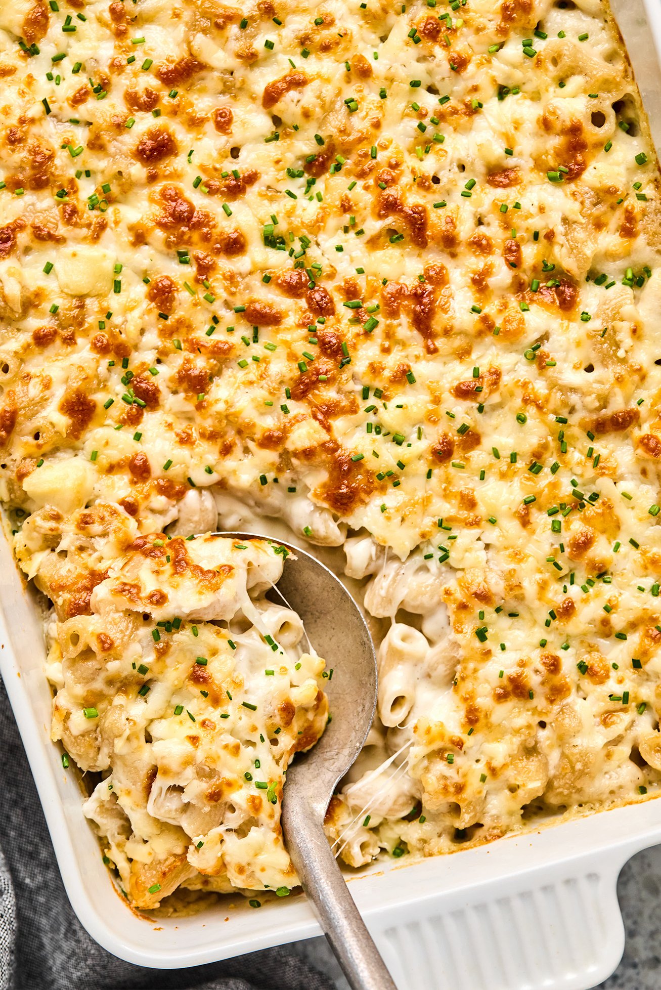 Goat cheese mac and cheese in a casserole dish with a spoon. 