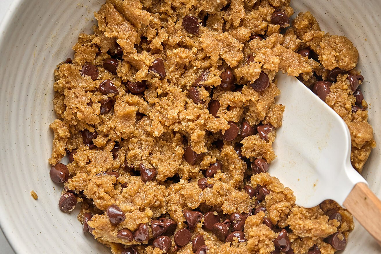 Cookie bar ingredients in a bowl mixed together with chocolate chips folded in. 