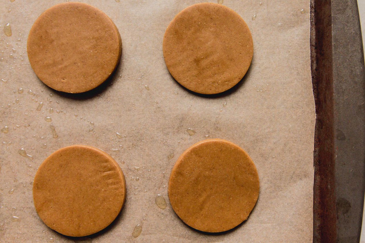 A baking sheet with gingerbread cookies on it before baking.