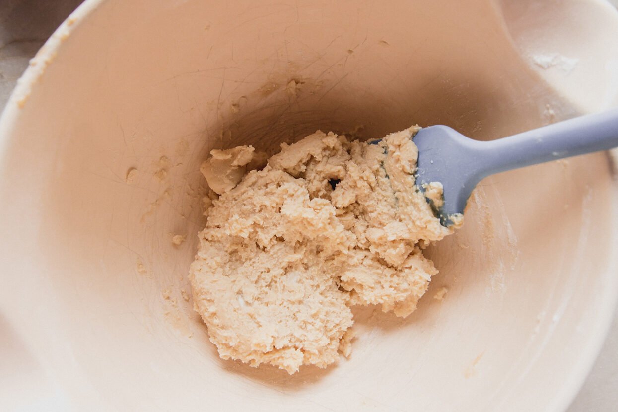 Spritz cookie dough in a bowl with a spatula. 