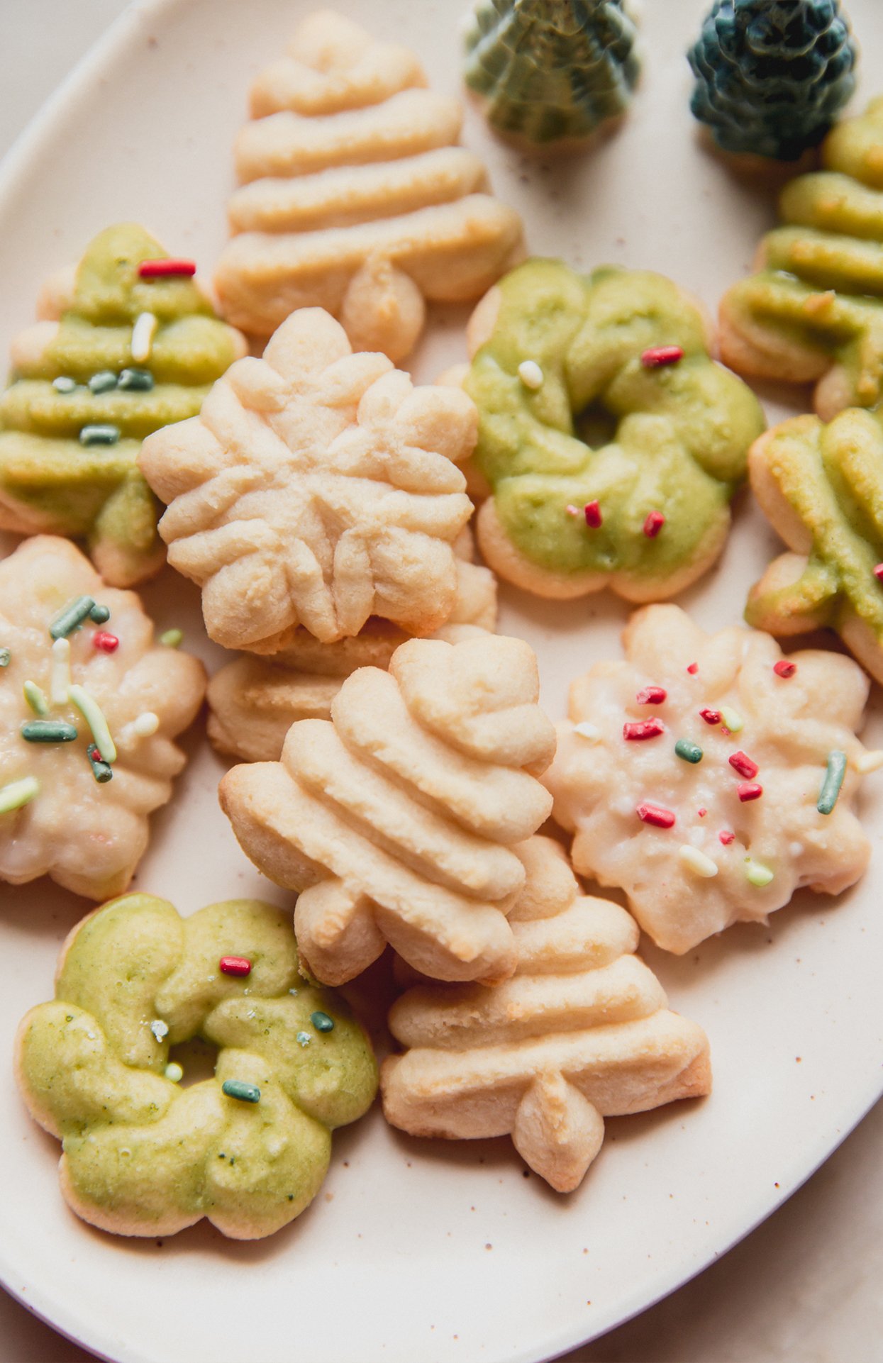 Spritz cookies topped with sprinkles on a platter.