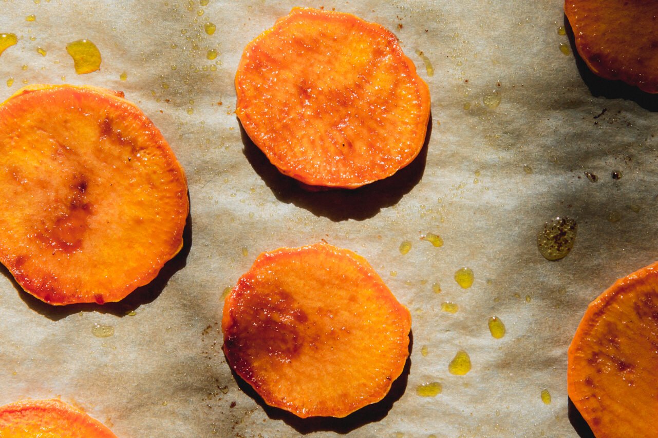 Baked sweet potato slices on a baking sheet.