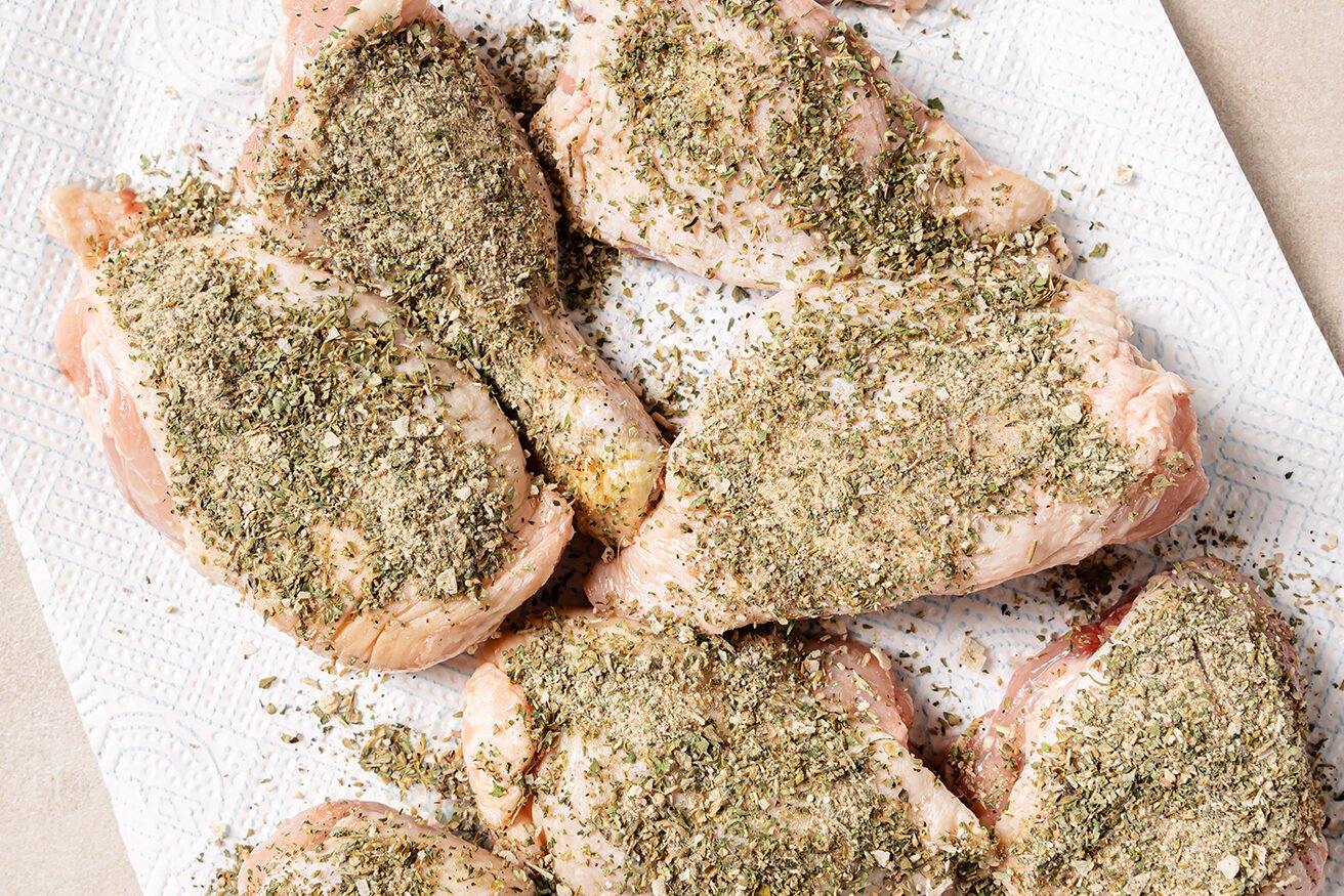 Raw turkey wings coated in a herb dry rub.