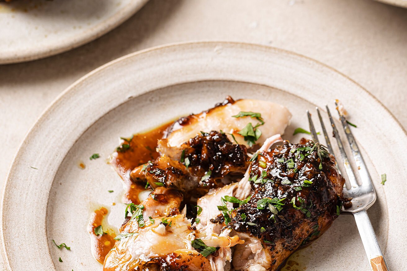 One turkey wing on a plate with a fork. 