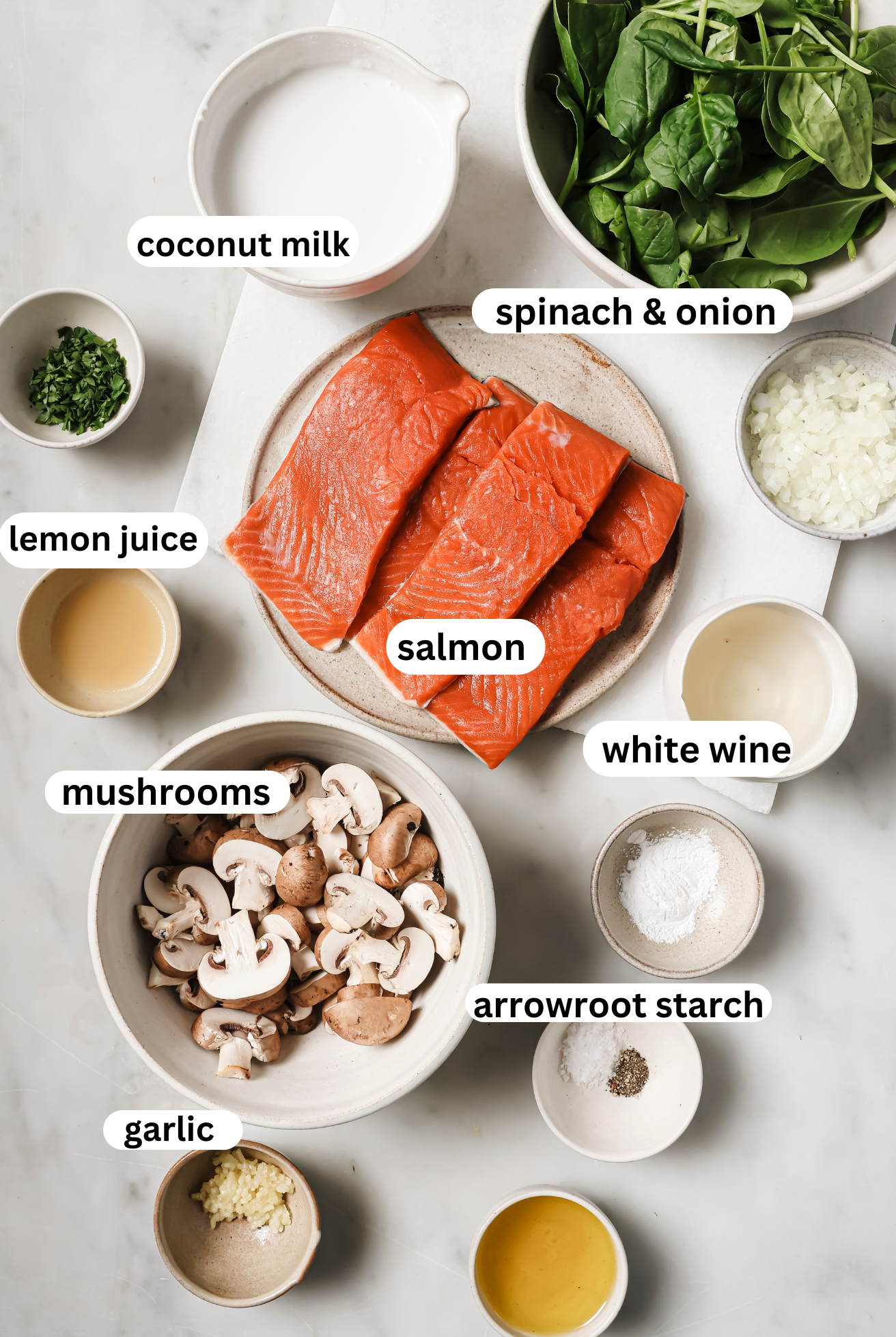 Salmon florentine ingredients laid out in bowls.