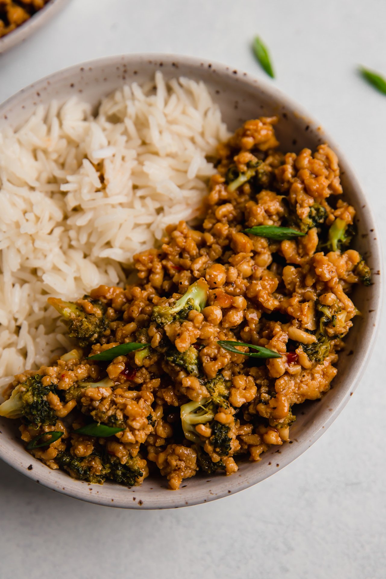 Firecracker ground chicken with broccoli in a bowl paired with rice.