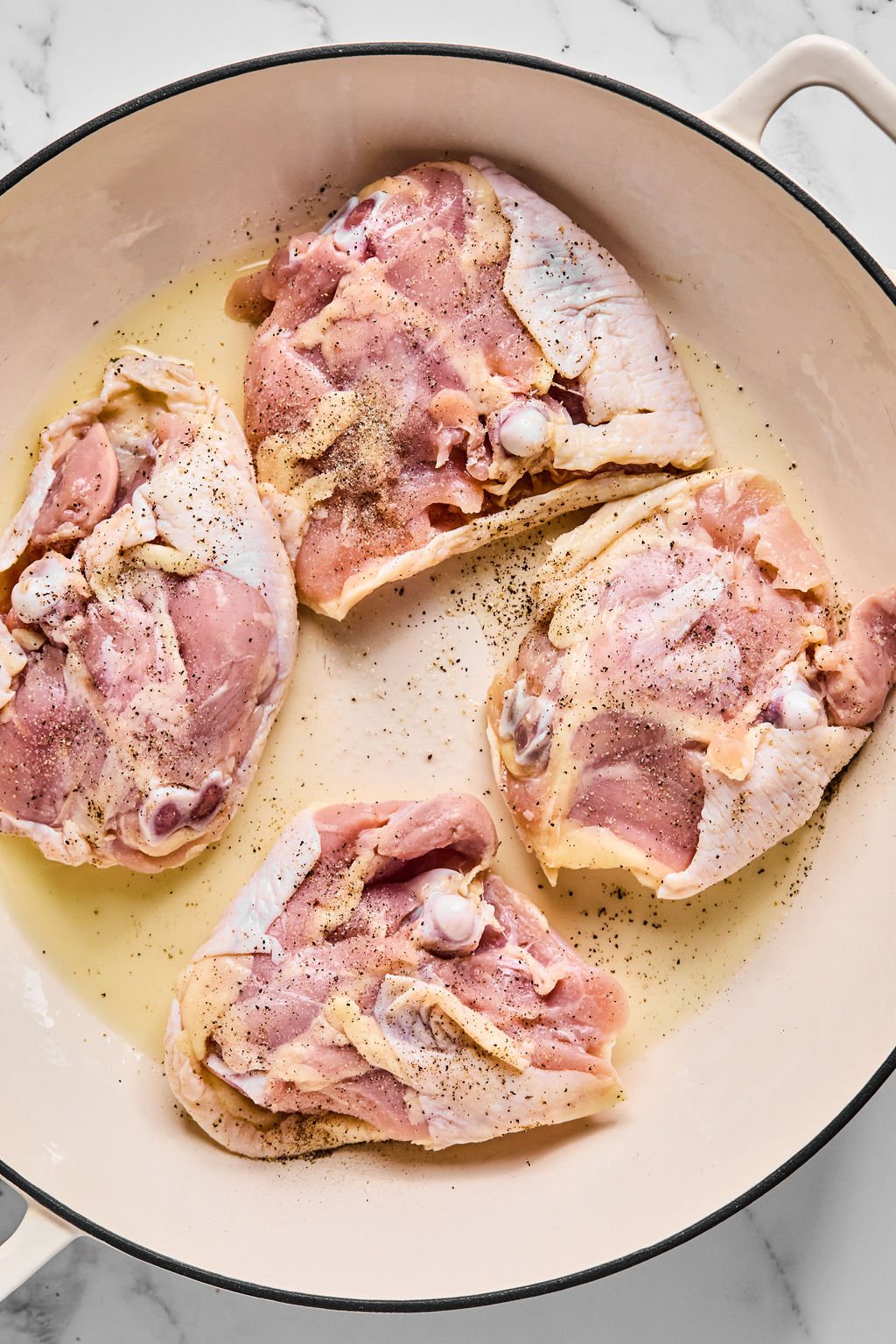 Chicken thighs skin side down in pan.