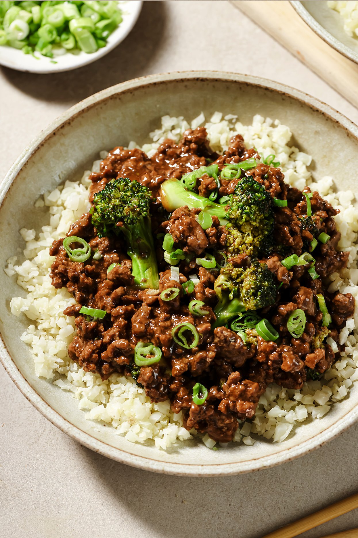 Ground beef and broccoli in a bowl with cauliflower rice. 