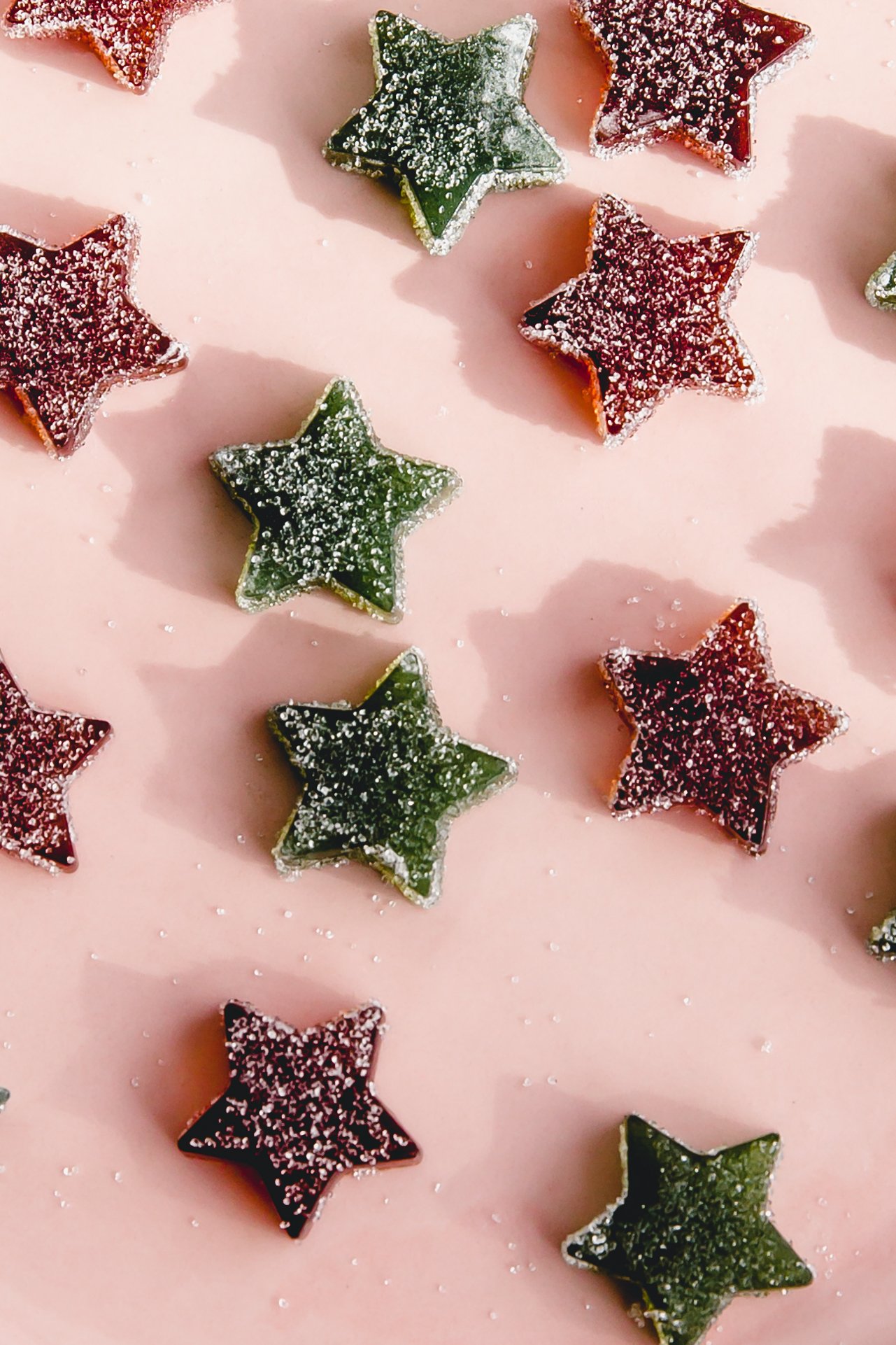 Star shaped gumdrops coated in sugar on a pink plate. 