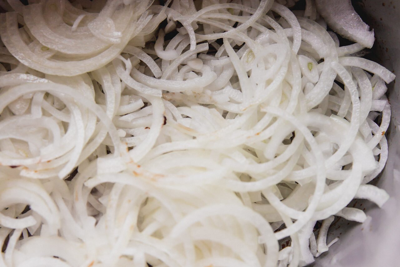 Onions in the Dutch oven before cooking.