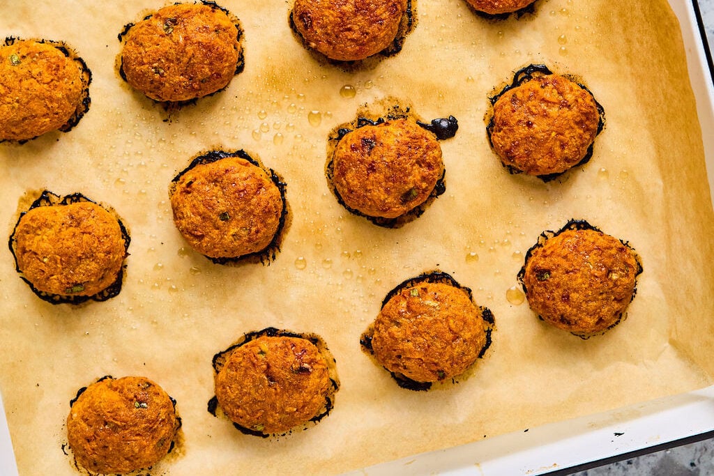 Cooked sweet potato chicken poppers on a sheet pan. 