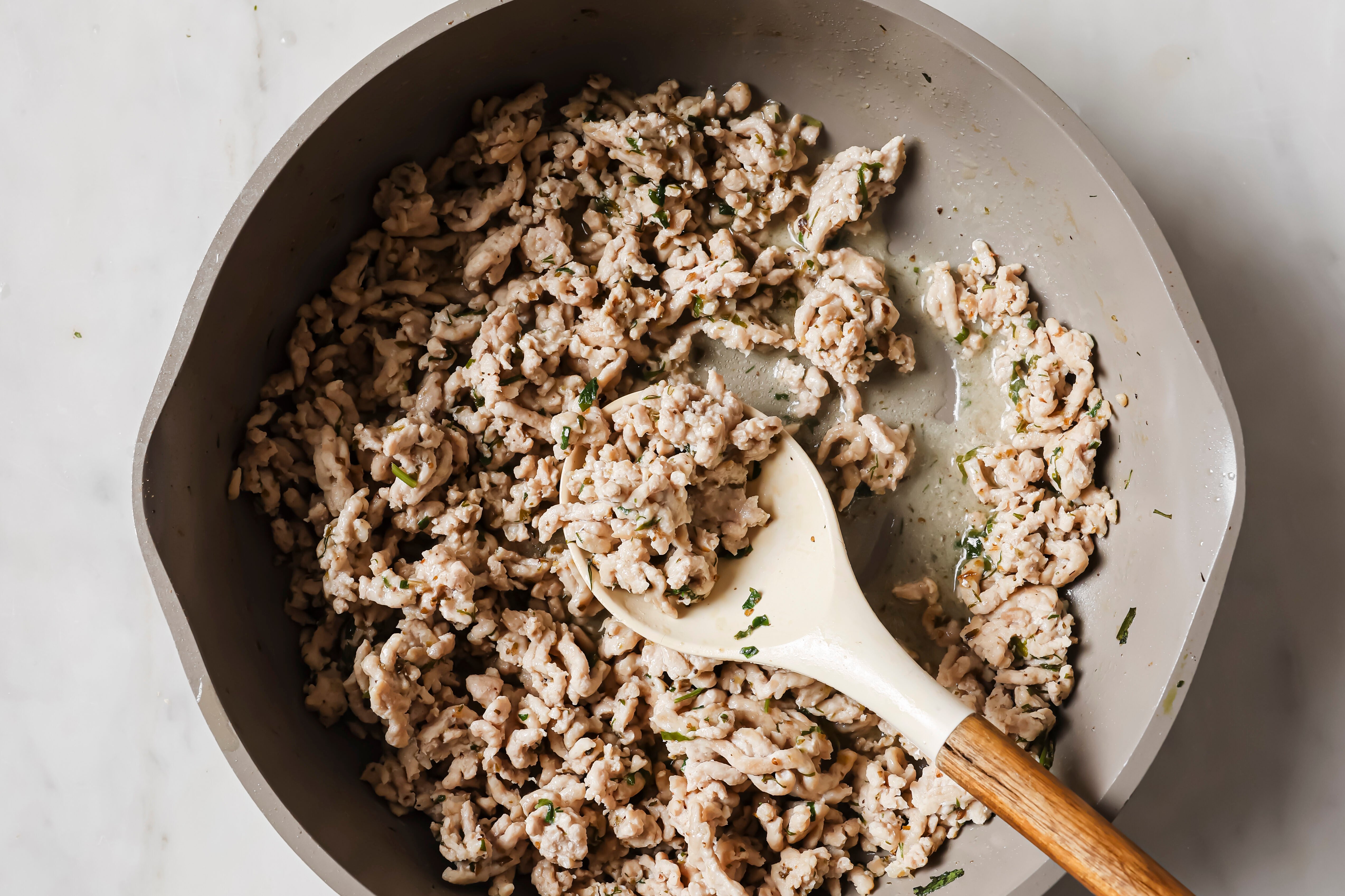 Ground chicken browned in a pan.