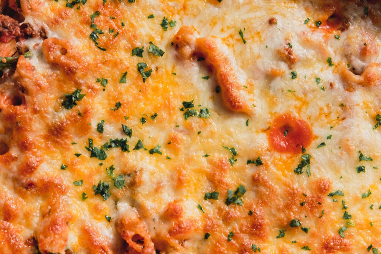No boil pasta bake topped with melted cheese and chopped parsley