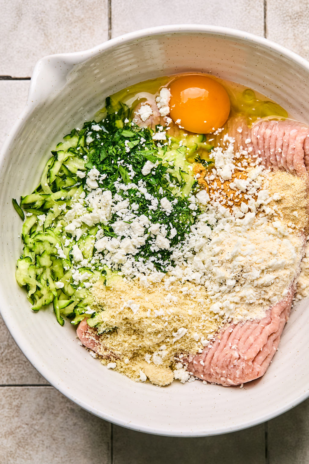 ground turkey, zucchini, almond flour, coconut flour, feta cheese, and herbs and seasonings in a bowl