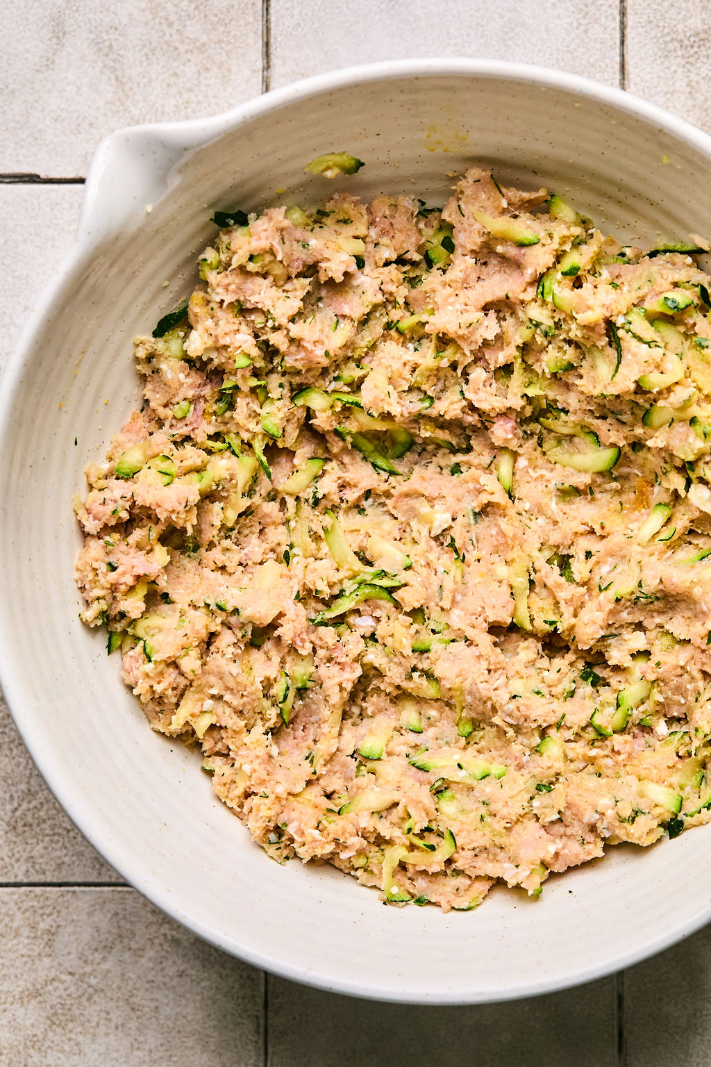 ground turkey, zucchini, almond flour, coconut flour, feta cheese, and herbs and seasoning mixture combined together in a bowl