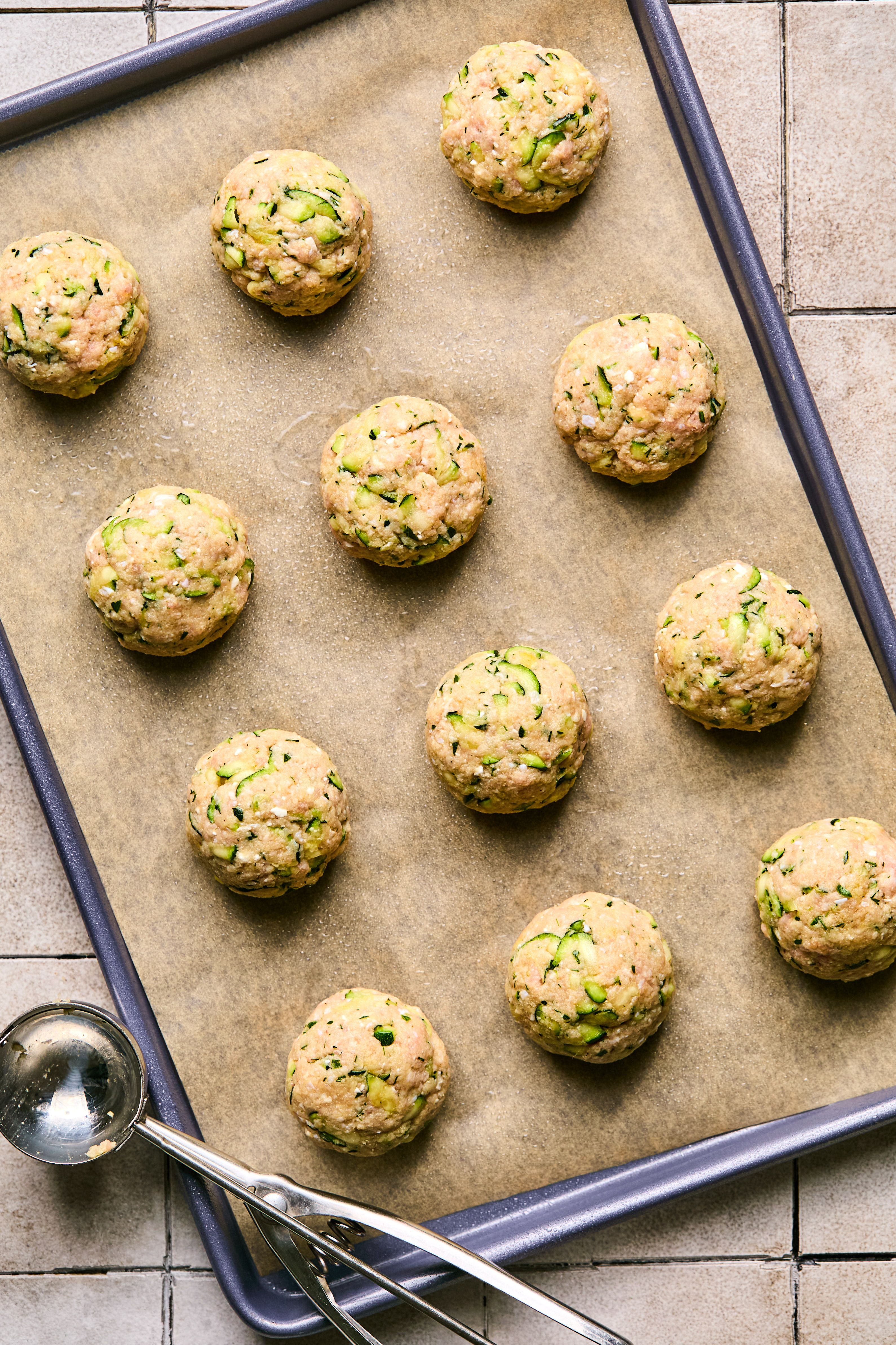 uncooked turkey feta meatballs on a parchment lined baking sheet 