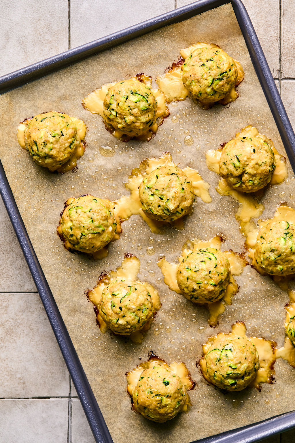 cooked turkey feta meatballs on a parchment lined baking sheet