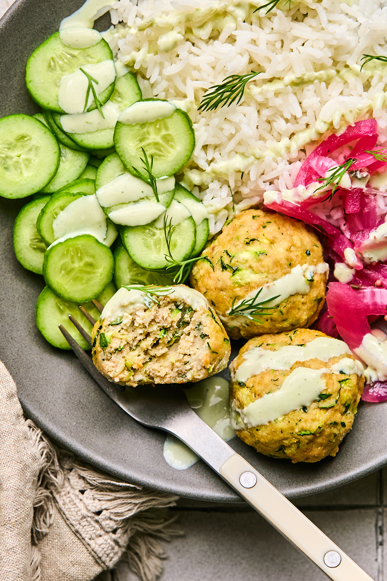 turkey feta meatballs with cucumber, rice, and pickled onion, topped with yogurt sauce